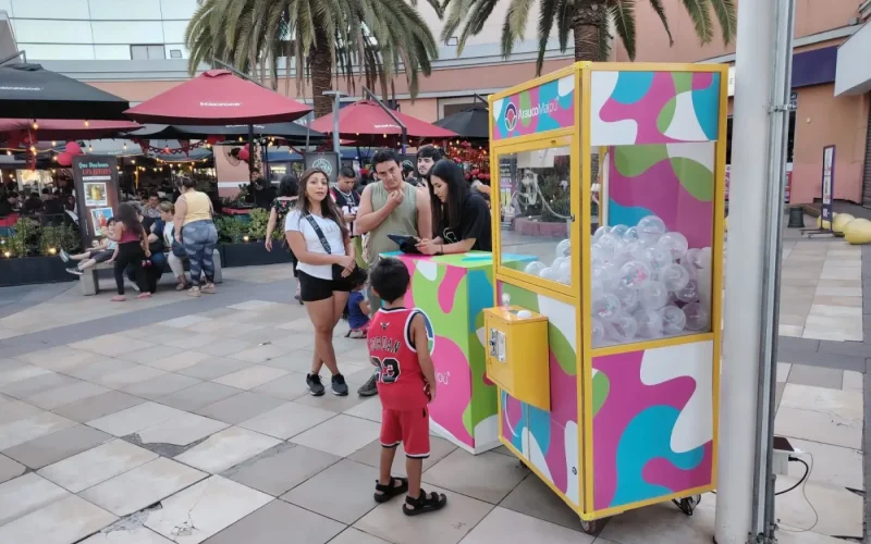 Niño frente a la peluchera colorida de Arauco en el paseo exterior del mall