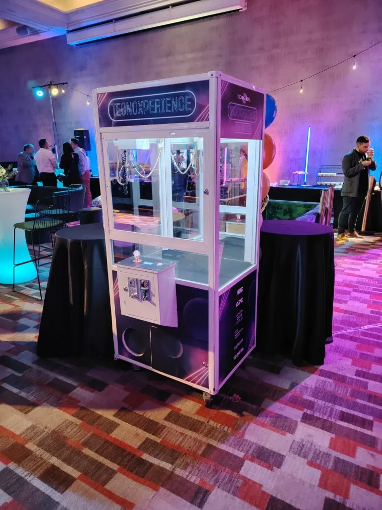Peluchera personalizada Tecnoxperience iluminada con luces neón en un evento corporativo