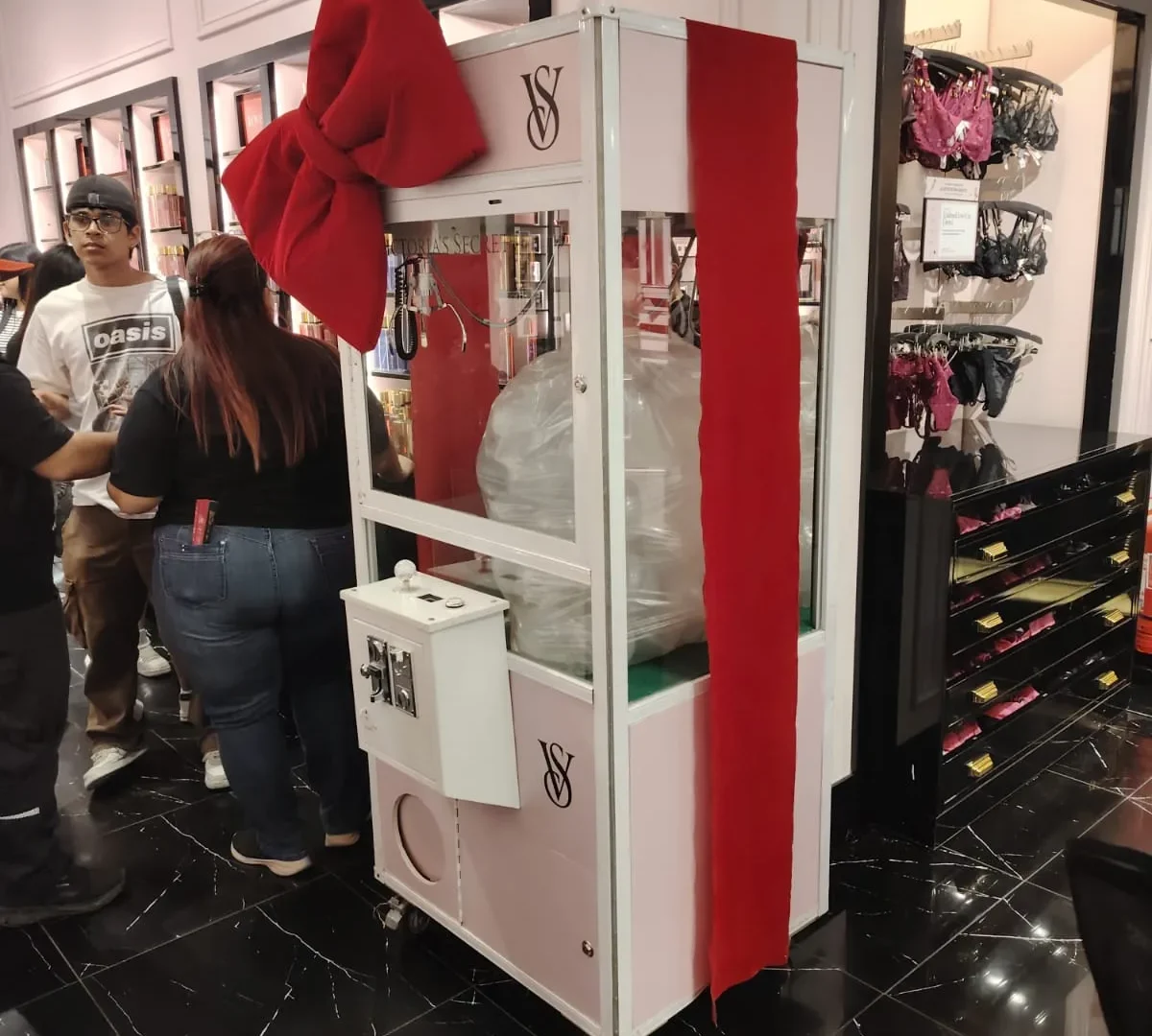 Peluchera personalizada Victoria's Secret decorada con un gran lazo rojo dentro de la tienda